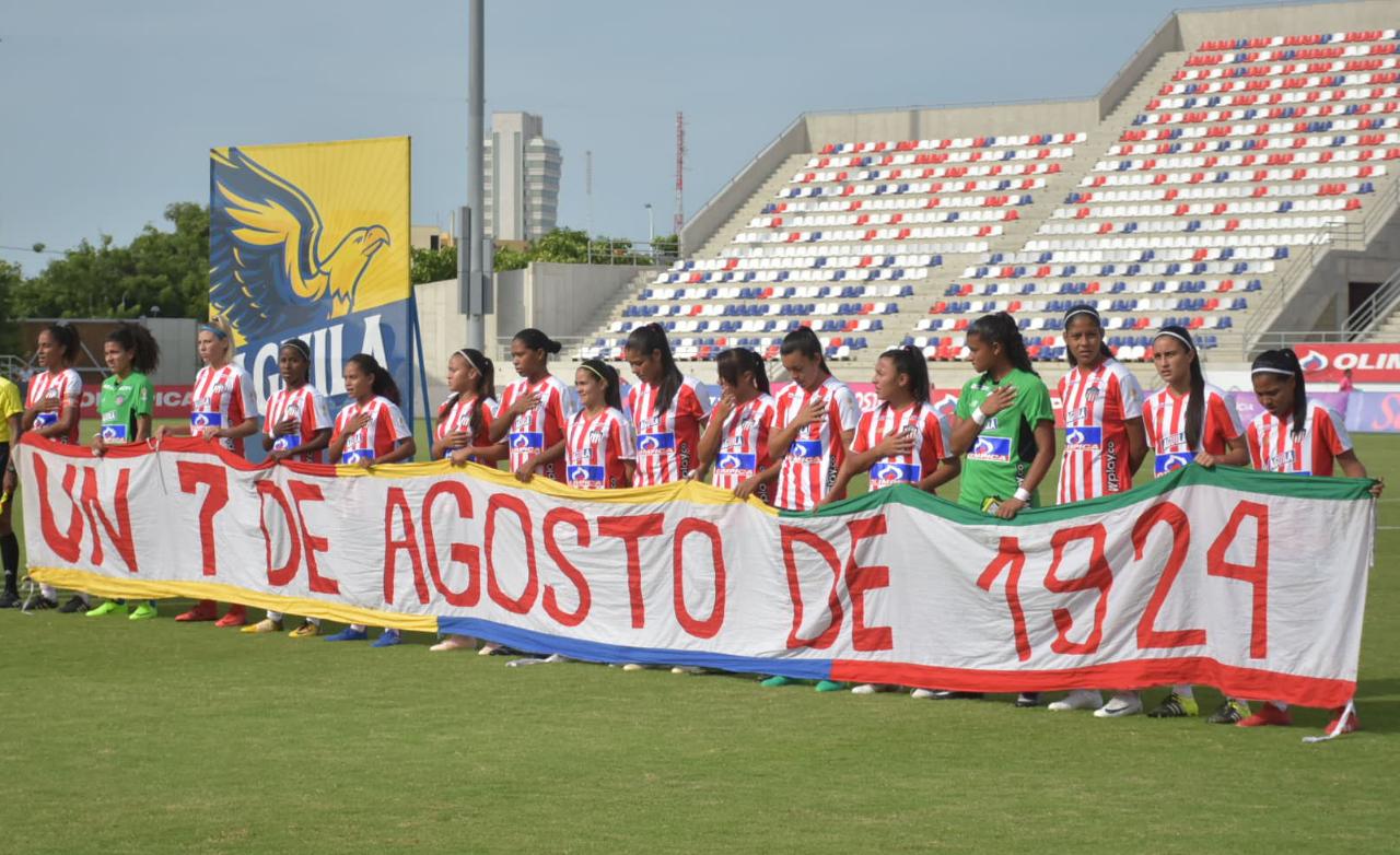 Las Tiburonas y la bandera del aniversario 95 de Junior. 