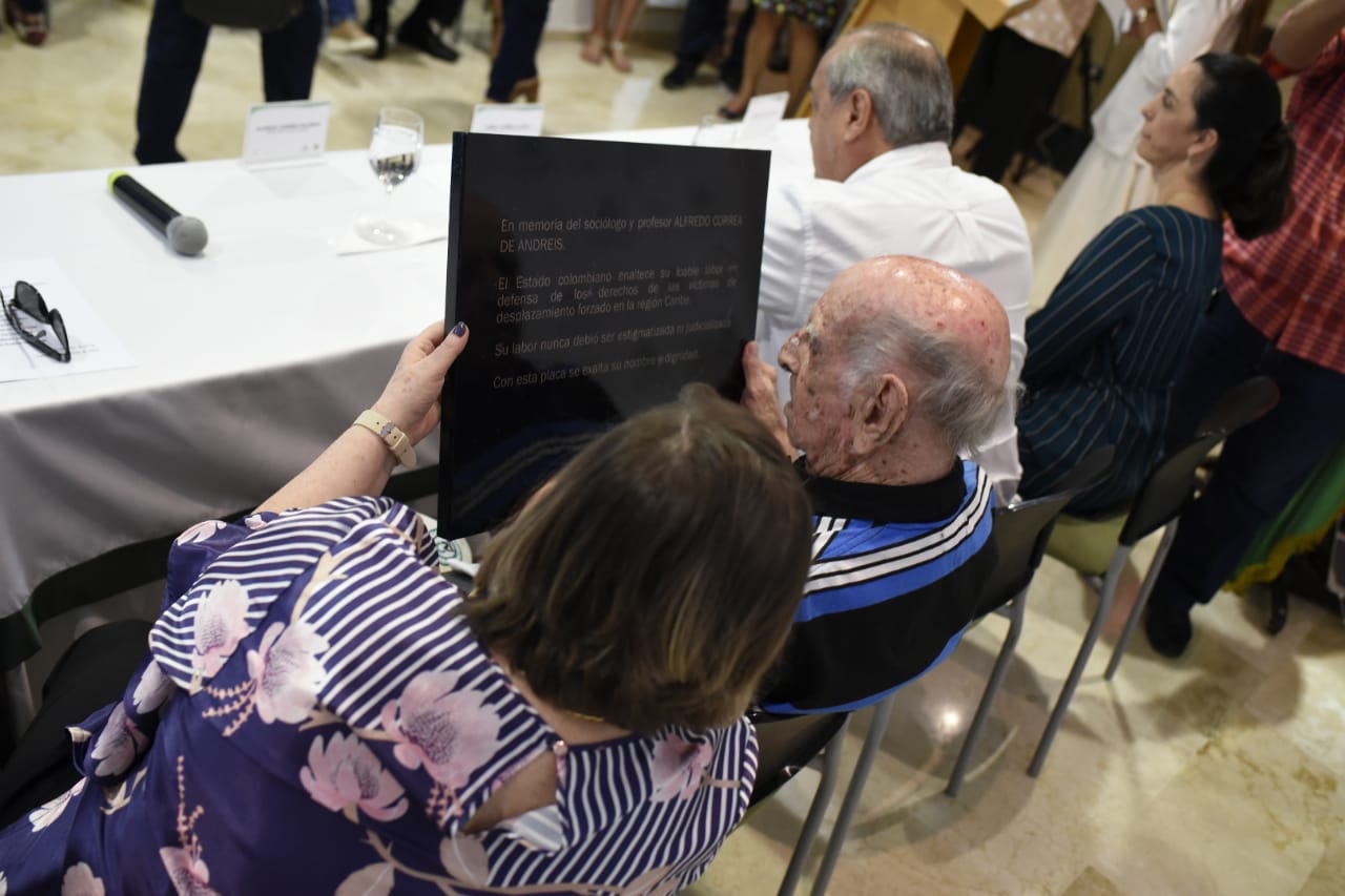 El papa de Alfredo Correa De Andréis observa la placa entregada por el Estado a la familia.