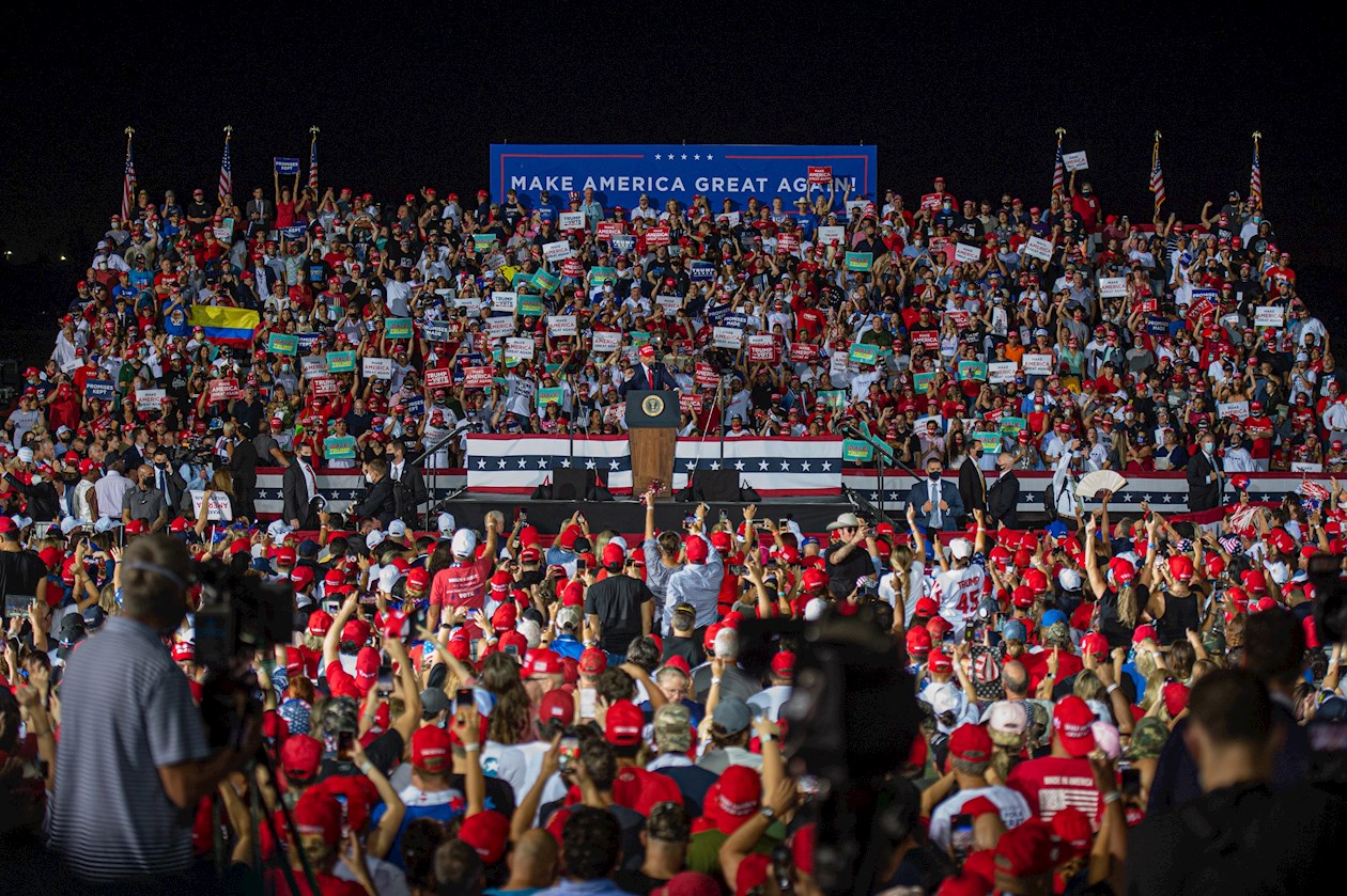 El presidente estadounidense Donald Trump saluda a sus simpatizantes este domingo durante un acto de su campaña electoral "Make America Great Again" celebrado a la media noche en el Aeropuerto de Opa-locka