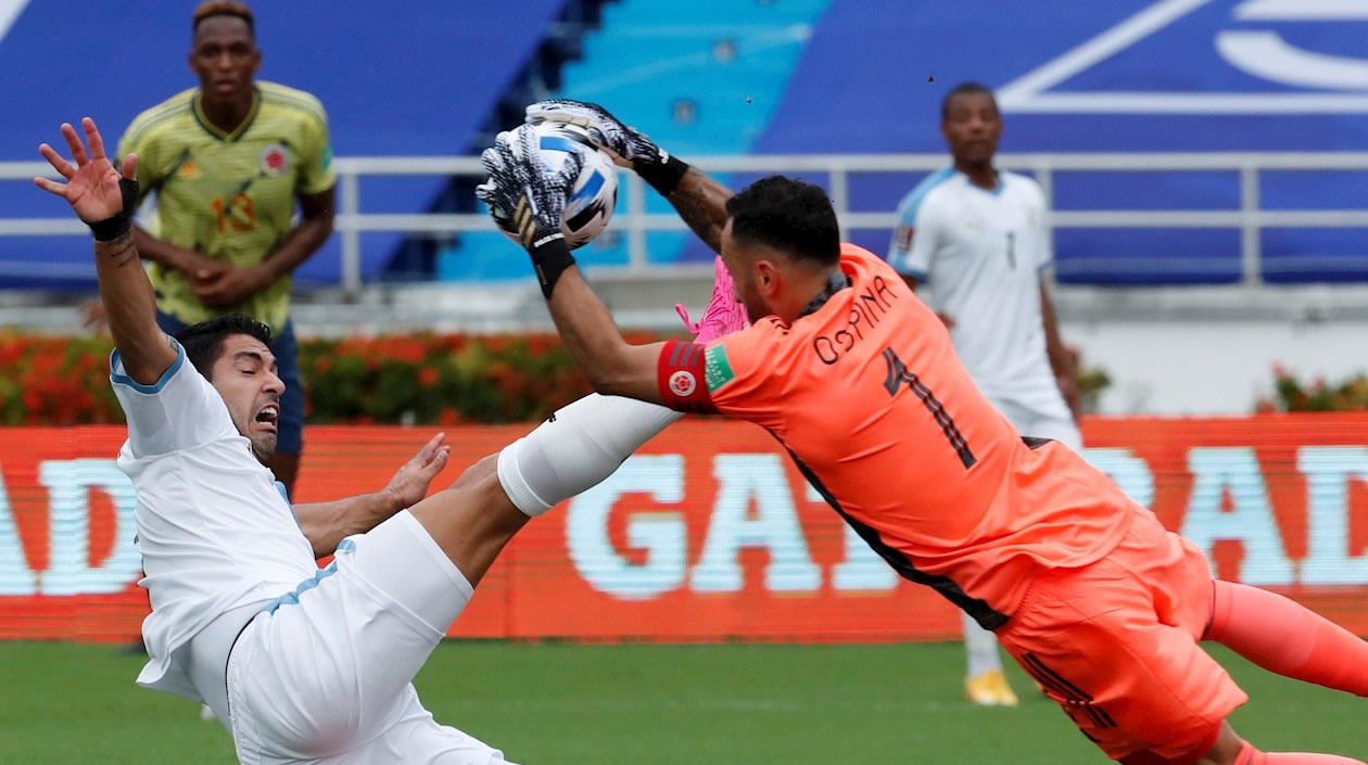 David Ospina  de Colombia disputa un balón con Luis Suárez