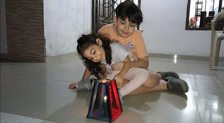 Lucía y Sebastián Zárate, encendiendo las velitas eb el barrio San Felipe de Barranquilla.