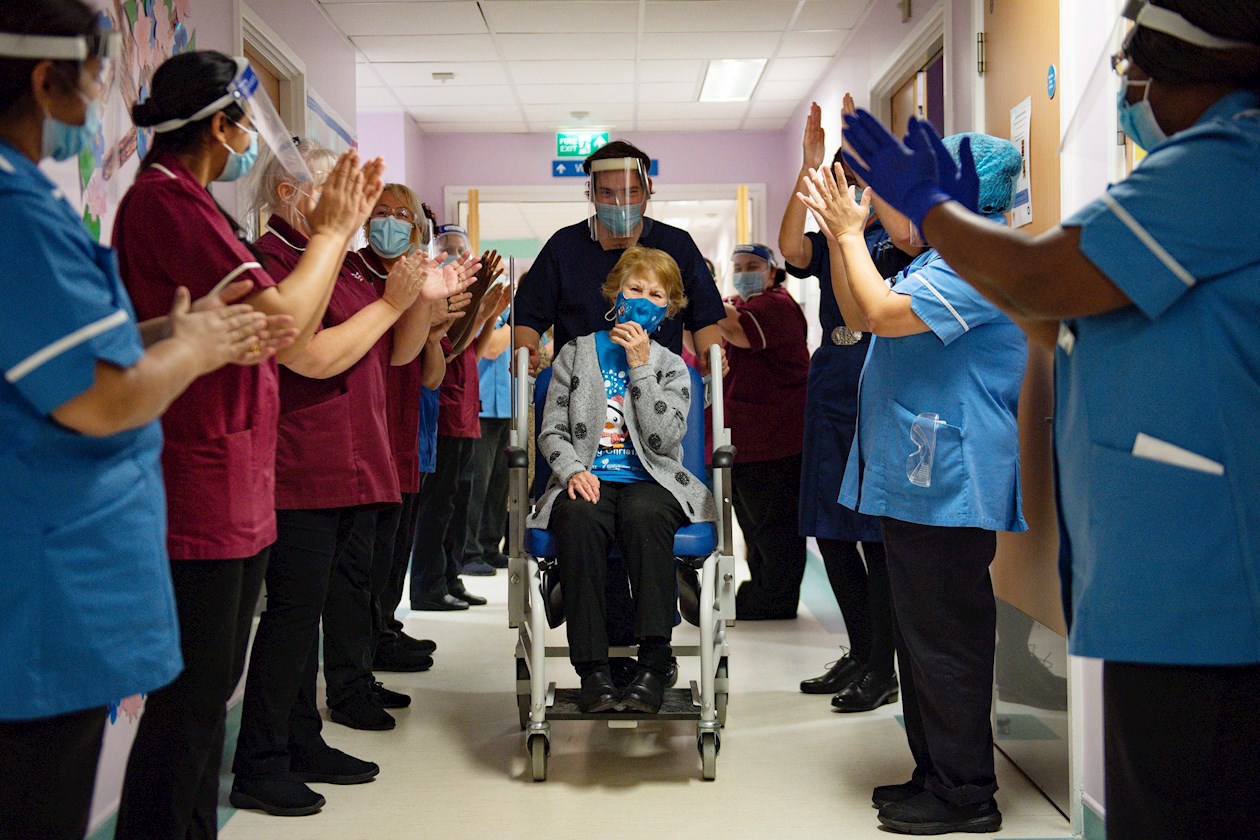 Margaret Keenan, de 90 años, es aplaudida por el personal cuando regresa a su sala después de convertirse en la primera persona en el Reino Unido en recibir la vacuna Pfizer / BioNtech Covid-19 al comienzo del programa de inmunización más grande en la historia del Reino Unido.