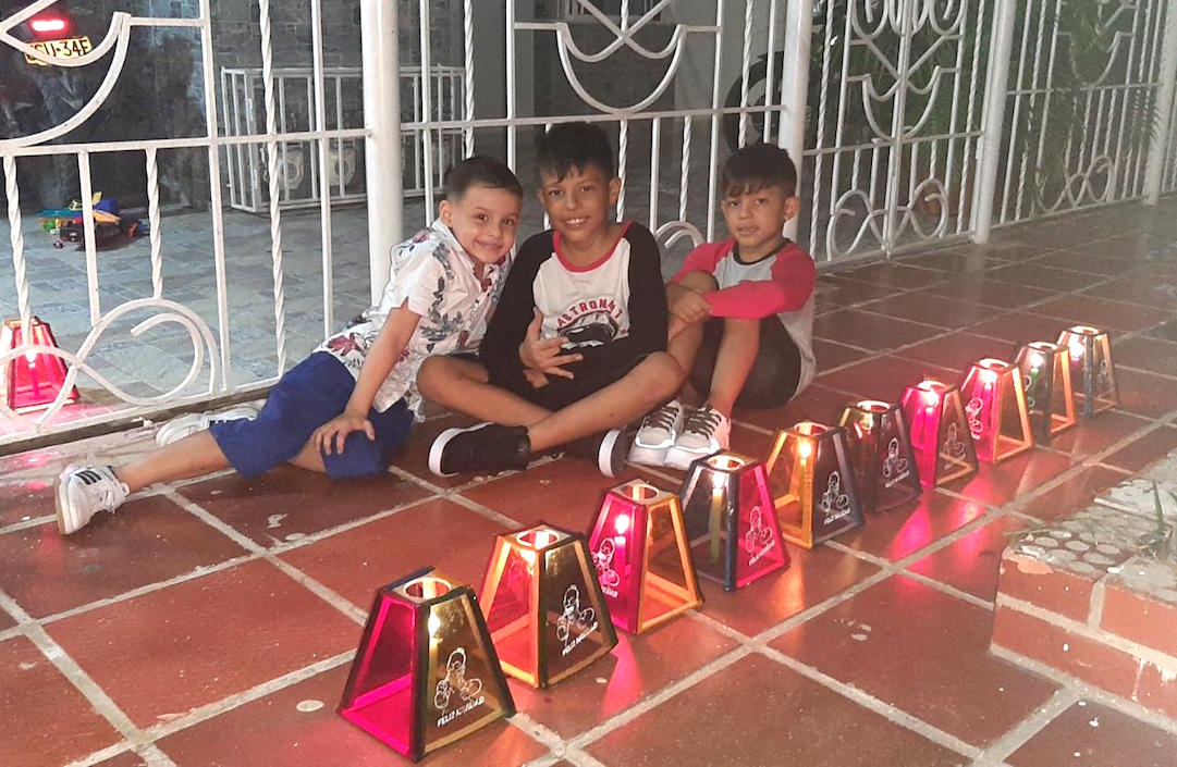 Niños frente a los farolitos encendidos en el barrio La Victoria.