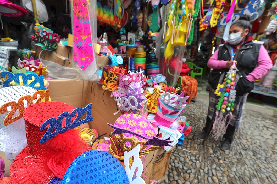 Una vendedora ofrece adornos de fiesta con la imagen de la Covid-19 y la vacuna en La Paz, Bolivia.