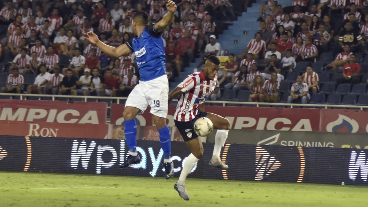 Freddy Hinestroza disputando el balón con David Gómez.