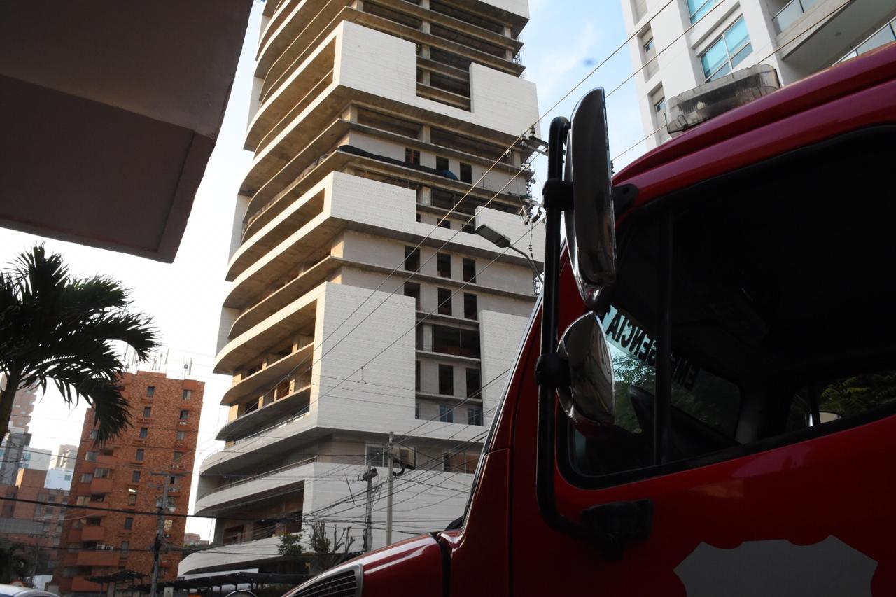 Los bomberos en el lugar. Al fondo, el edificio donde cayó la pared de ladrillos.