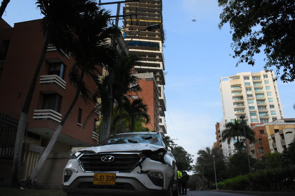 La camioneta afectada y al fondo el edificio donde cedió la pared de ladrillo.