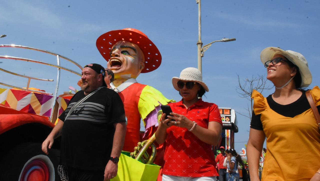 Turistas apreciando el colorido de las carrozas.
