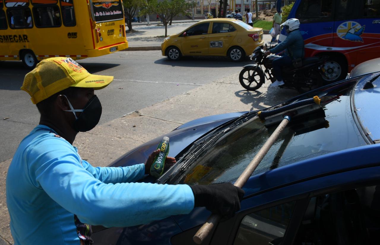 Este joven se gana la vida limpiando vidrios, pero también se protege.
