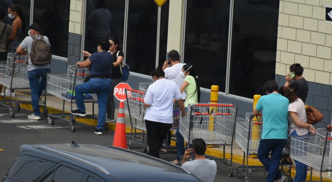 Muchas personas protegidas con tapabocas en las filas de clientes.