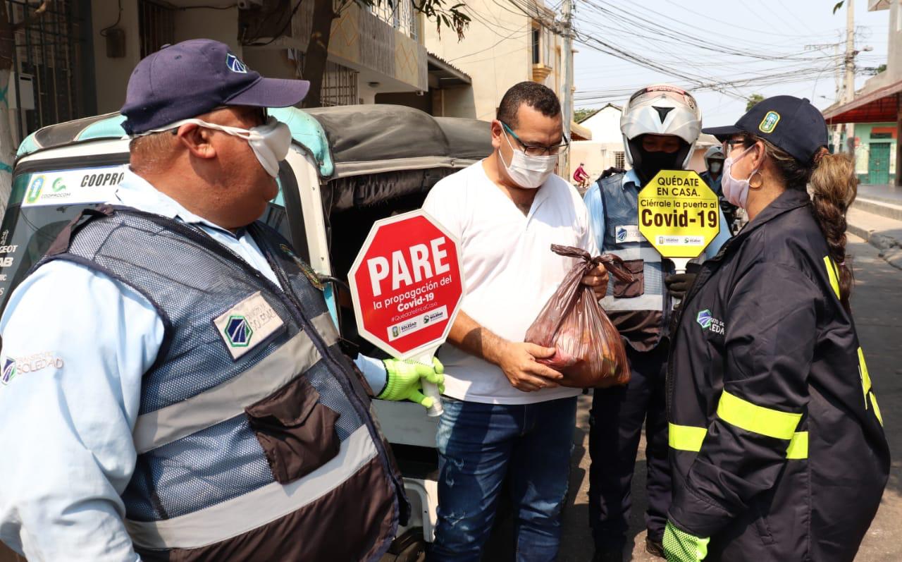 Directora del Tránsito en Soledad, Yomaira Solano y varios agentes, entregando las ayudas alimentarias.