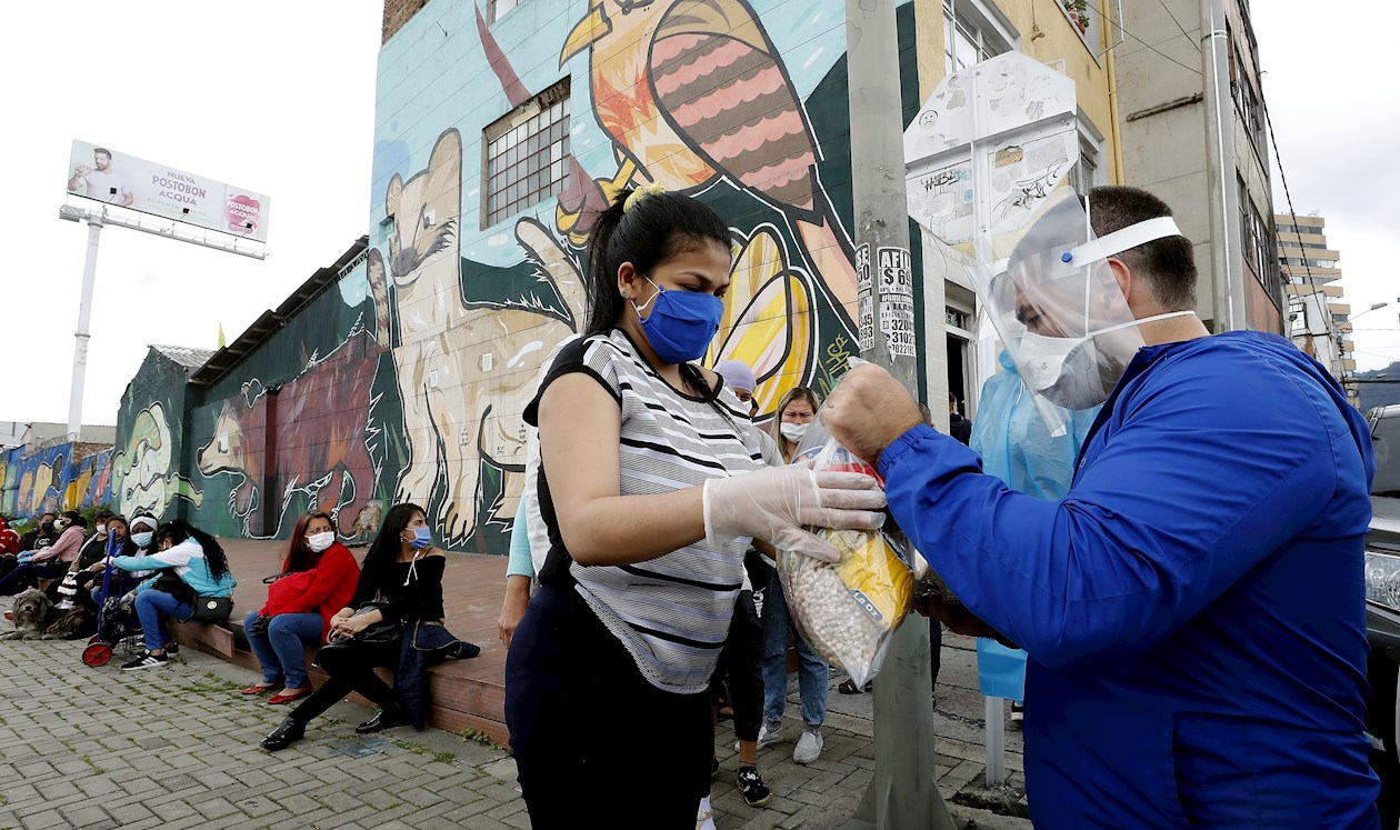 El representante a la cámara por el partido conservador, Juan Carlos Wills (d), entrega mercados a mujeres de Sintrasexco este lunes en Bogotá (Colombia)