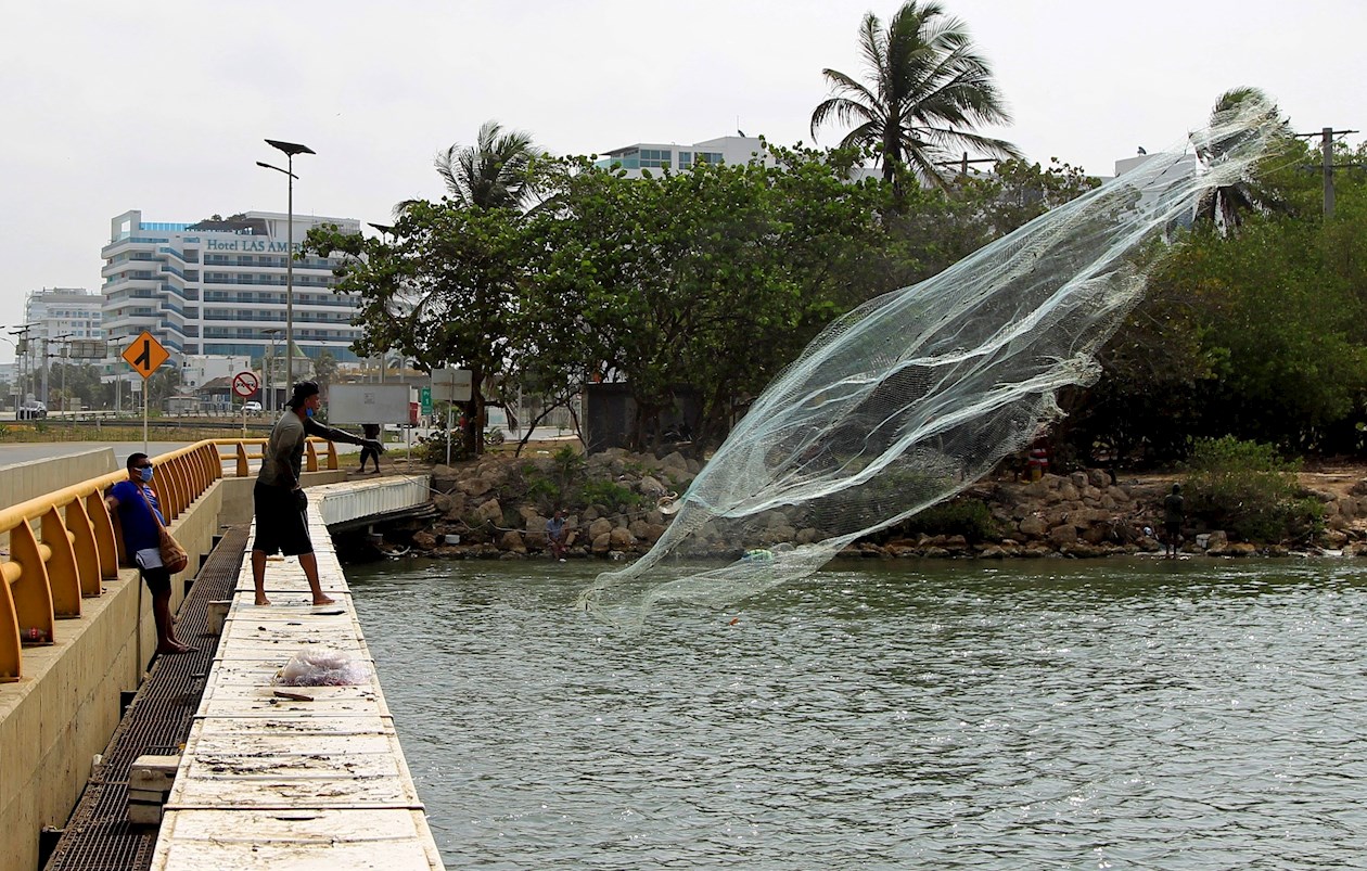 EFE/Ricardo Maldonado Un par de pescadores de La Boquilla, un corregimiento vecino de Cartagena de Indias (Colombia), fueron registrados al lanzar una red cerca de la desembocadura de un río.