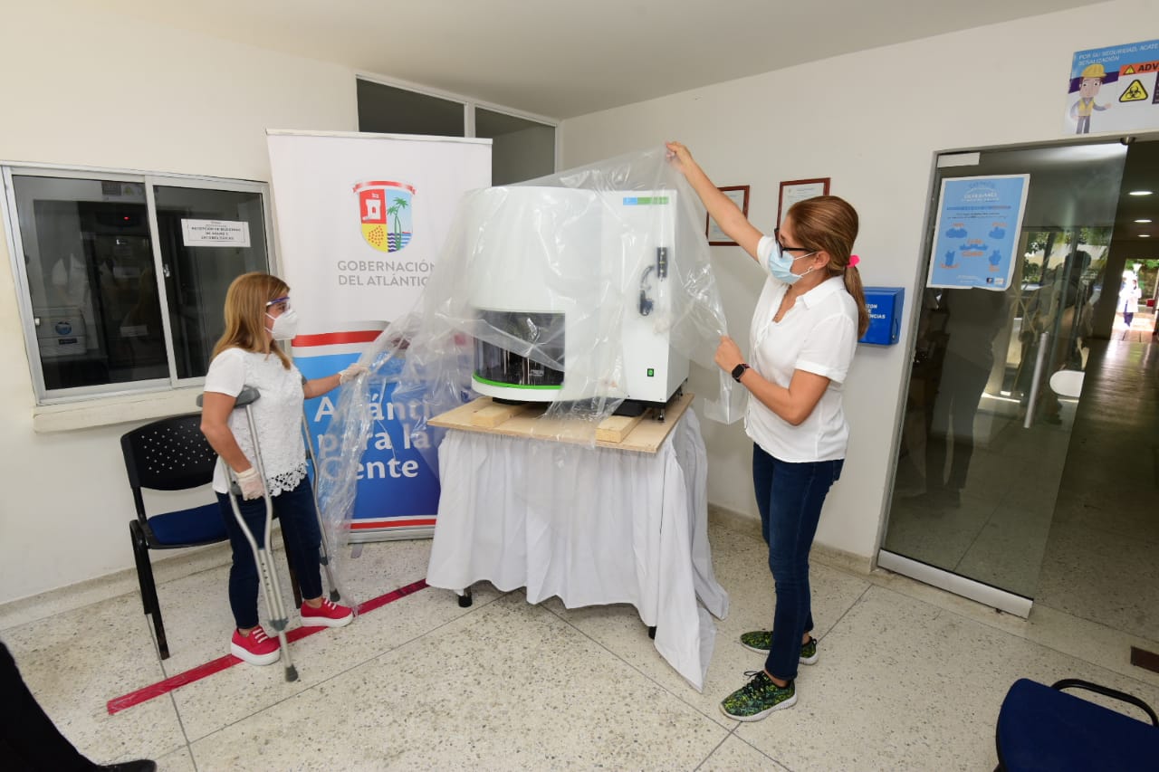 La Gobernadora del Atlántico, Elsa Noguera y la secretaria de Salud, Alma Solano, con el nuevo robot para procesar pruebas de Covid-19.