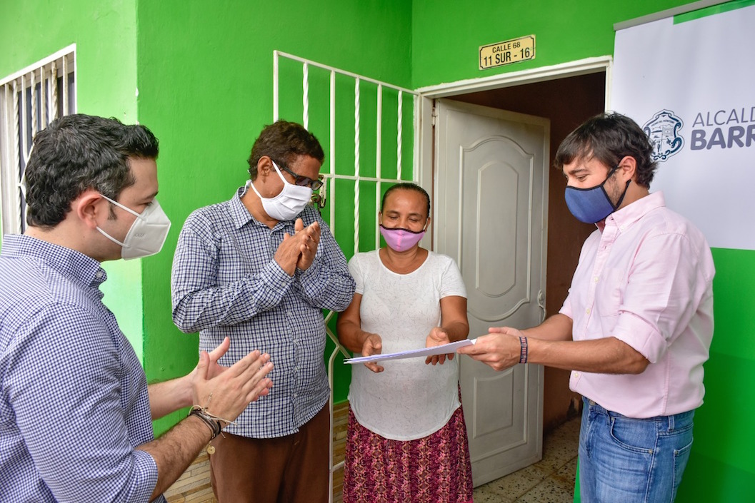 El Alcalde Jaime Pumarejo entregando un título de vivienda.