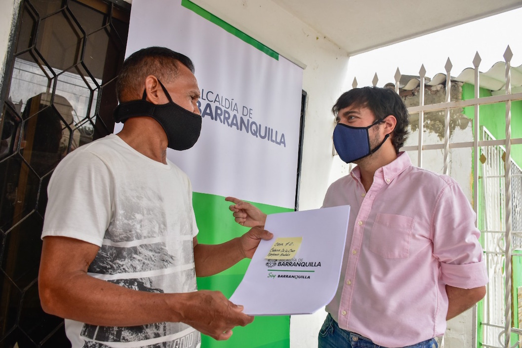 El Alcalde Jaime Pumarejo entregando un título de vivienda.