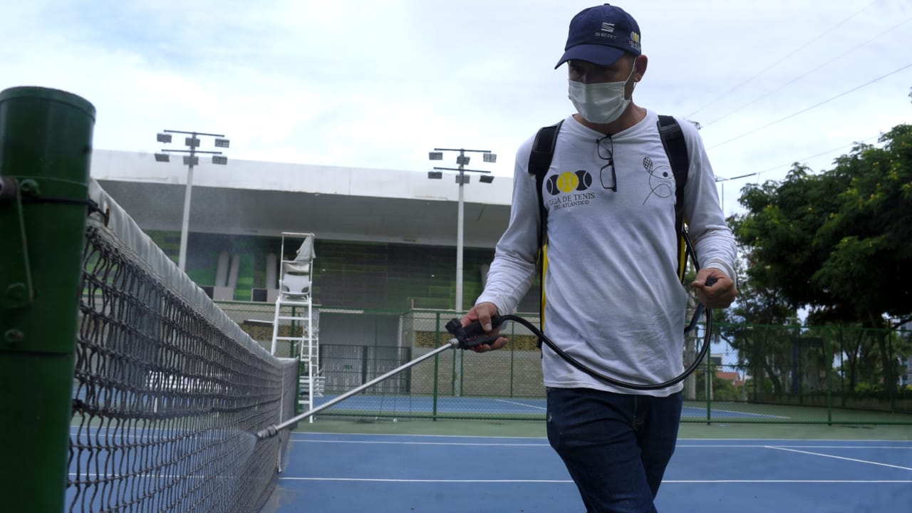 Desinfección en una de las mallas de las canchas de tenis