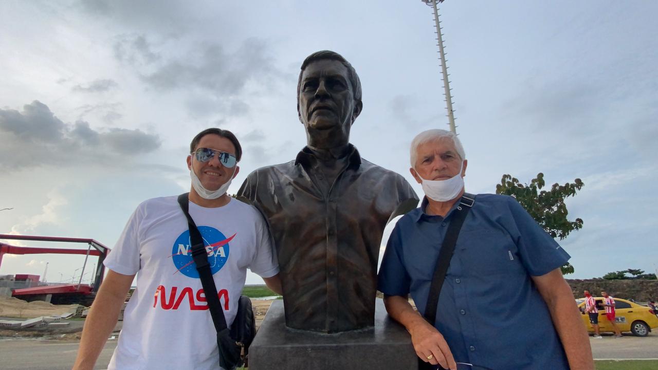 Julio Comesaña posando al lado de su estatua con su hijo.