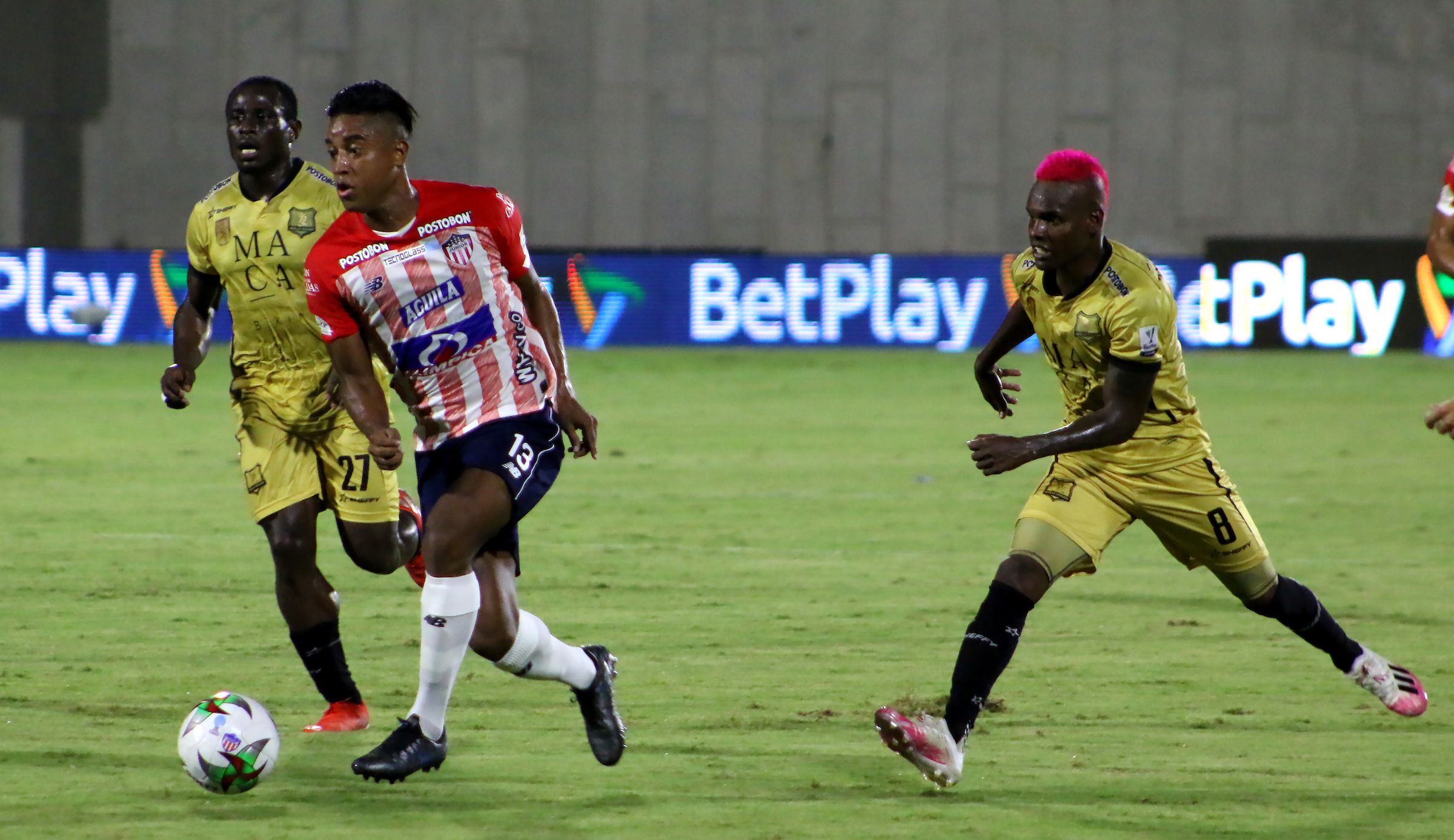 Cristian Higuita frente a dos adversarios.