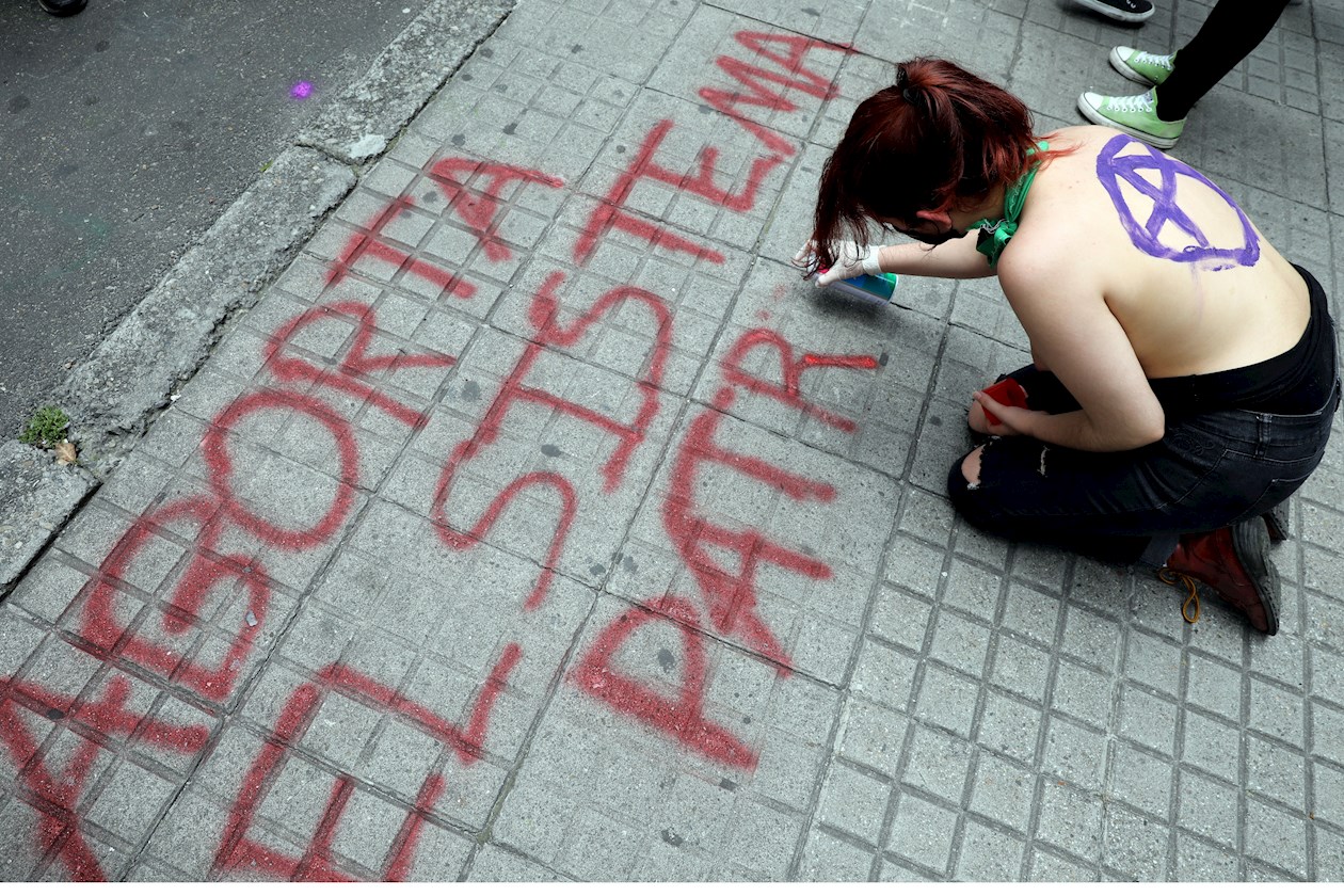 Una manifestante pinta un letrero en una calle de Bogotá (Colombia)