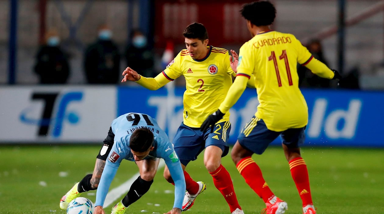Brian Rodríguez de Uruguay disputa un balón con John Medina y Juan Cuadrado