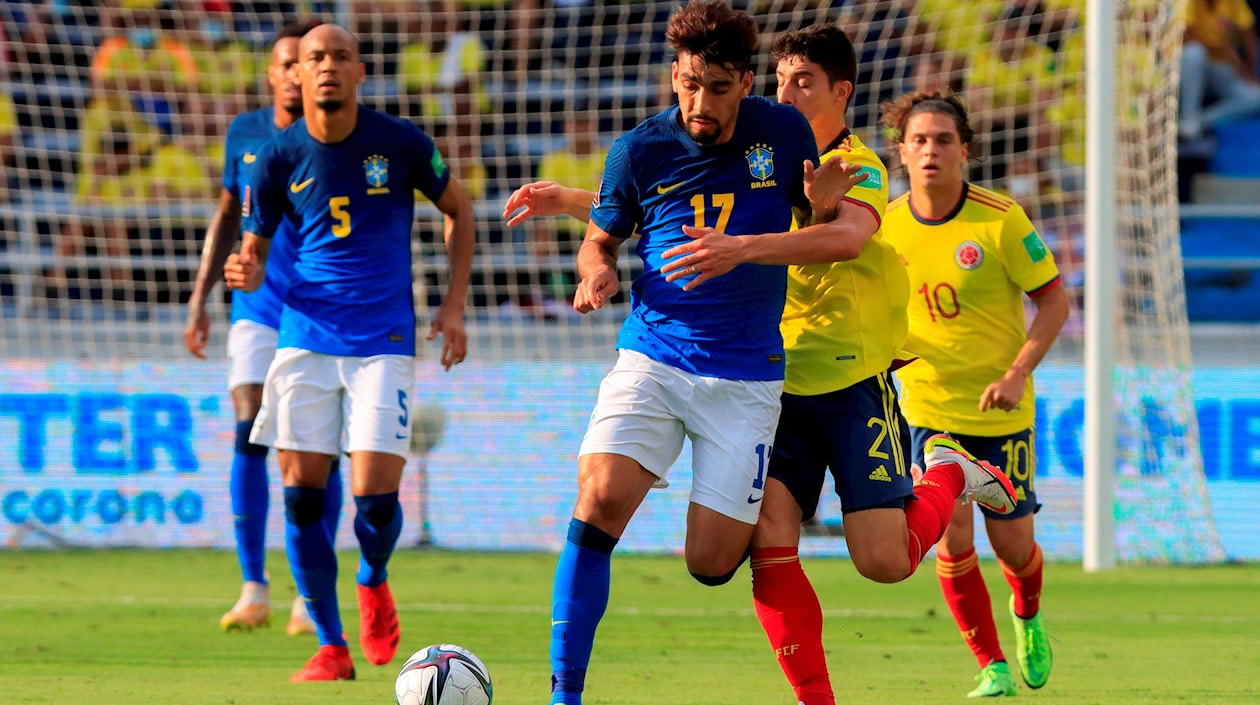 Stefan Medina de Colombia disputa un balón con Lucas Paquetá