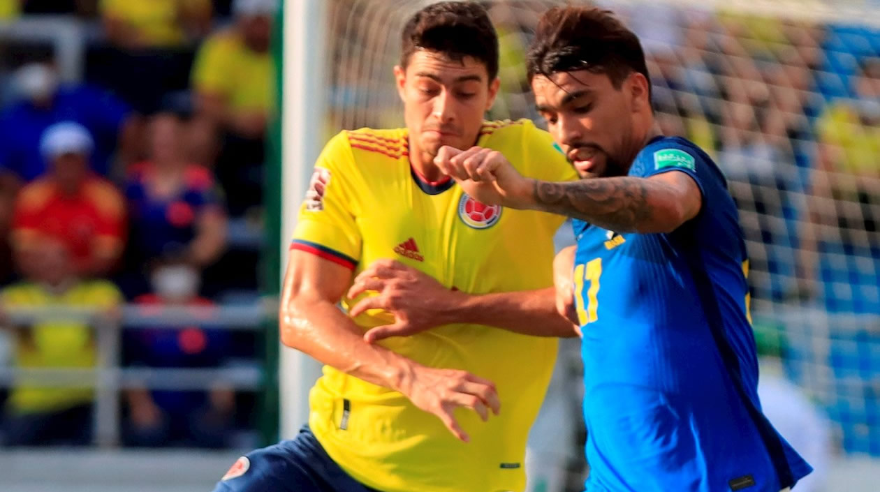 Stefan Medina de Colombia disputa un balón con Lucas Paquetá de Brasil hoy