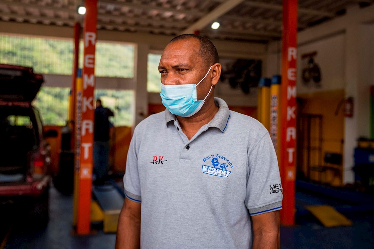 Dos empleados descansan en un taller mecánico propiedad de Remberto Herrera.