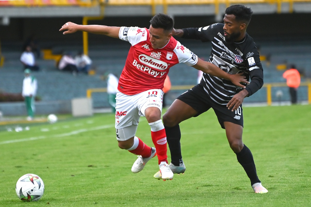 Luis 'Cariaco' González disputando el balón con John Velásquez.