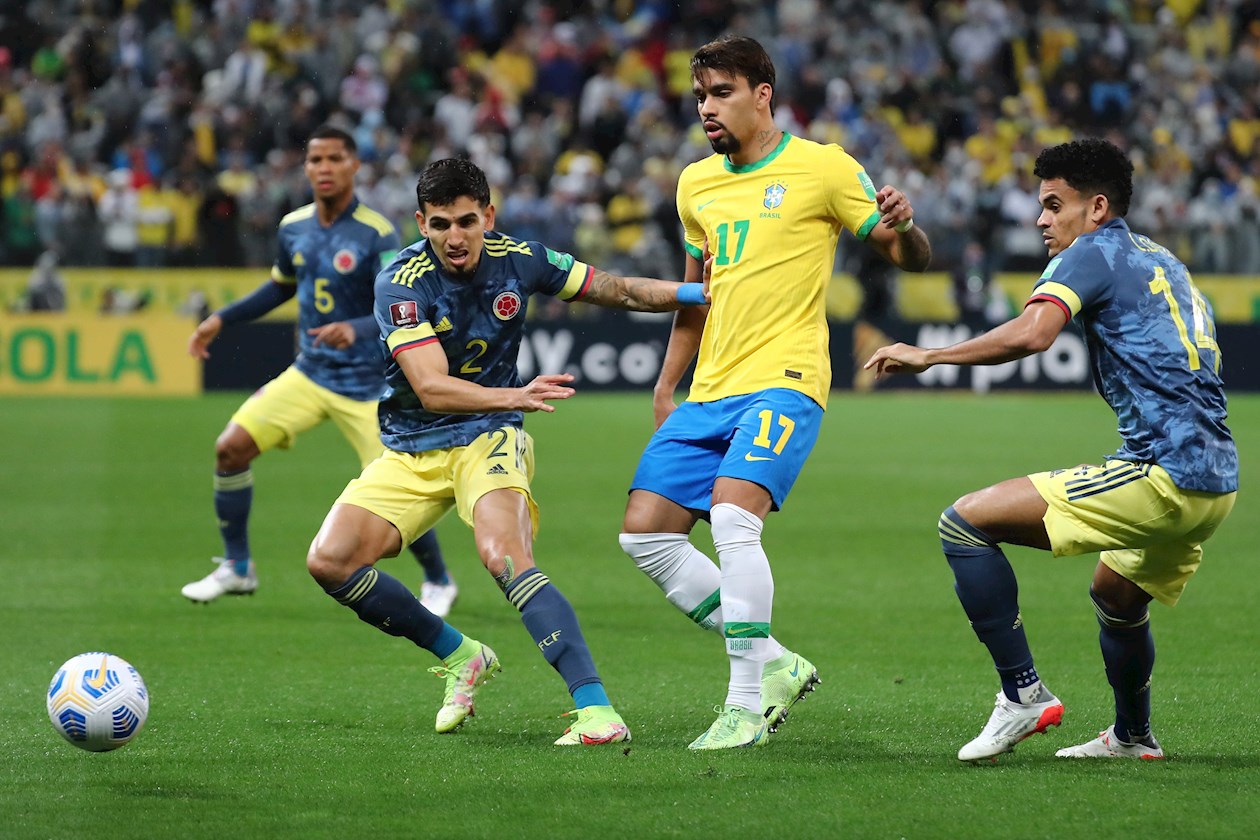 Lucas Paquetá de Brasil disputa el balón con Daniel Muñoz y Luis Díaz de Colombia
