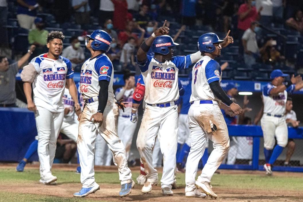 Peloteros de Caimanes celebran tras anotar el racimo de tres carreras.