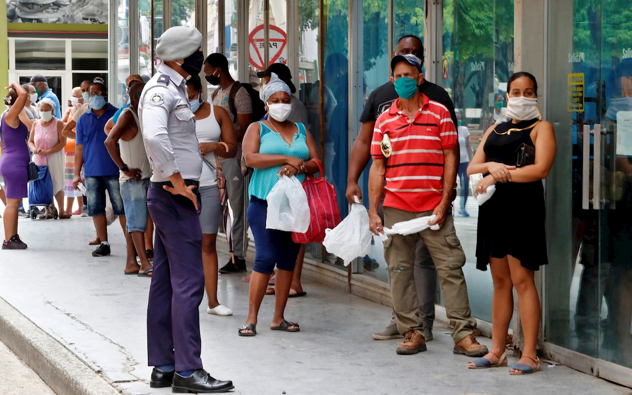 Personas con tapabocas hacen fila afuera de un centro comercial para comprar productos, en La Habana (Cuba)