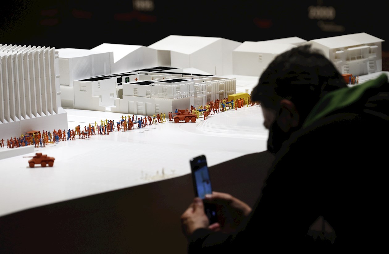 Un visitante toma fotografías de una maqueta de la Casa del Florero en la exposición "Huellas de desaparición" en el Museo de Arte Miguel Urrutia (MAMU), el 11 de diciembre de 2021 en Bogotá.