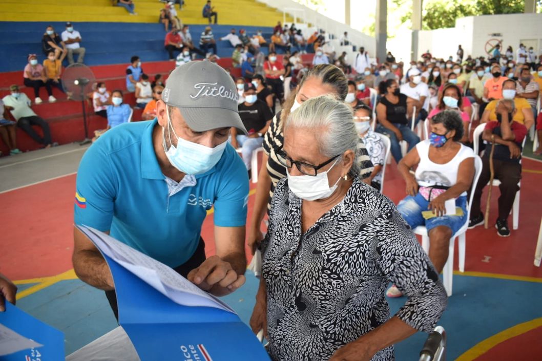 El Alcalde José Fernando Vargas enseñando el título a una beneficiaria.