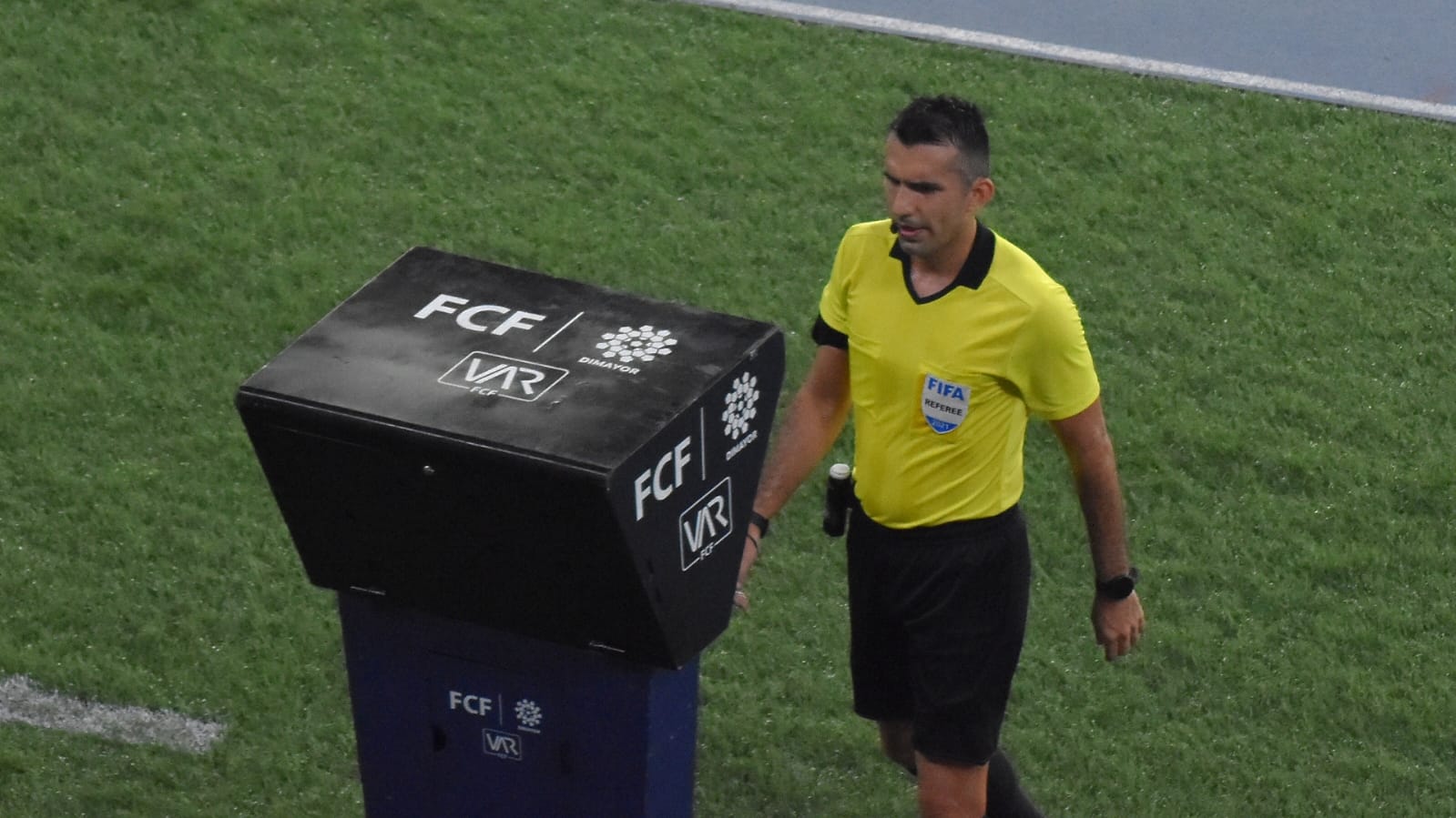 El árbitro revisando una jugada con el VAR.