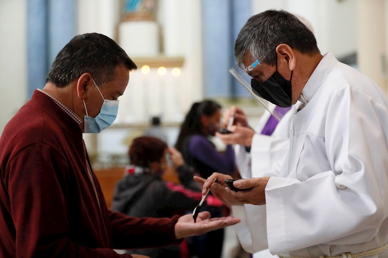  Un sacerdote entrega cenizas en la mano a los fieles que participan de la celebración católica del miércoles de ceniza, hoy en la Catedral Primada en Bogotá.
