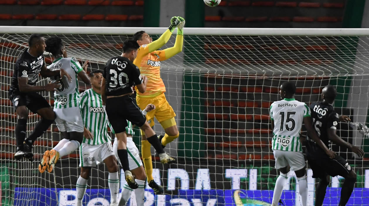 Aldair Quintana despeja un peligro ante la llegada de Fabián Ángel.