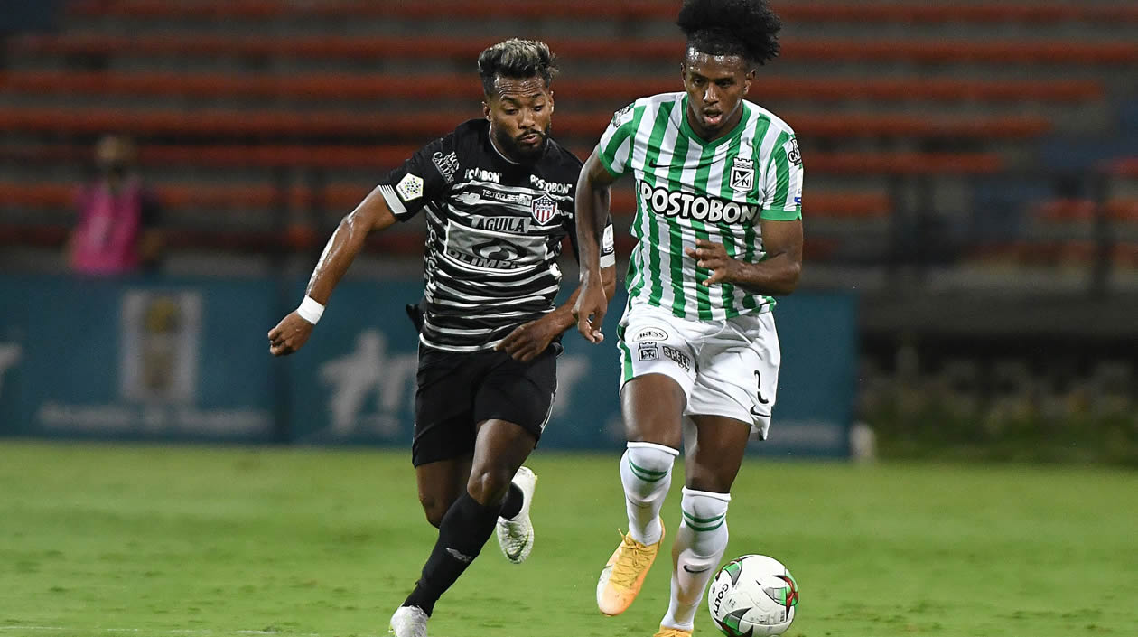 Luis 'Cariaco' González disputando el balón con Juan David cabal.