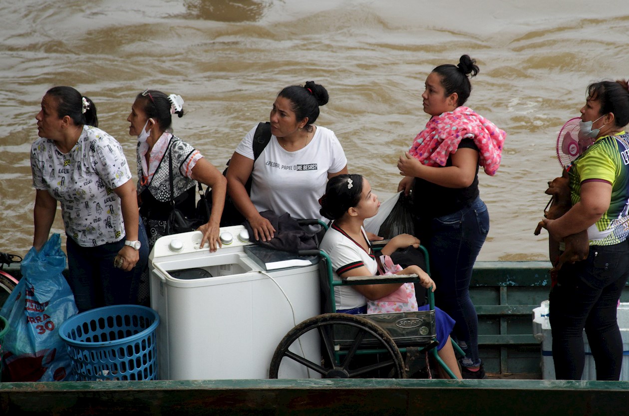 Migrantes venezolanos cruzan en botes desde La Victoria, en Venezuela, hasta Arauquita, en Colombia.