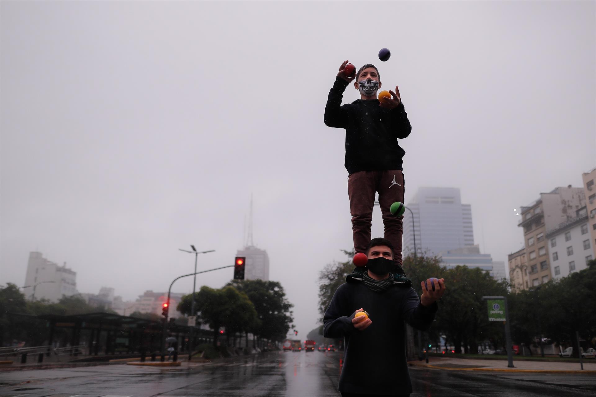 Dos personas hacen malabares en una calle vacía hoy, durante el primer día de confinamiento en Buenos Aires.