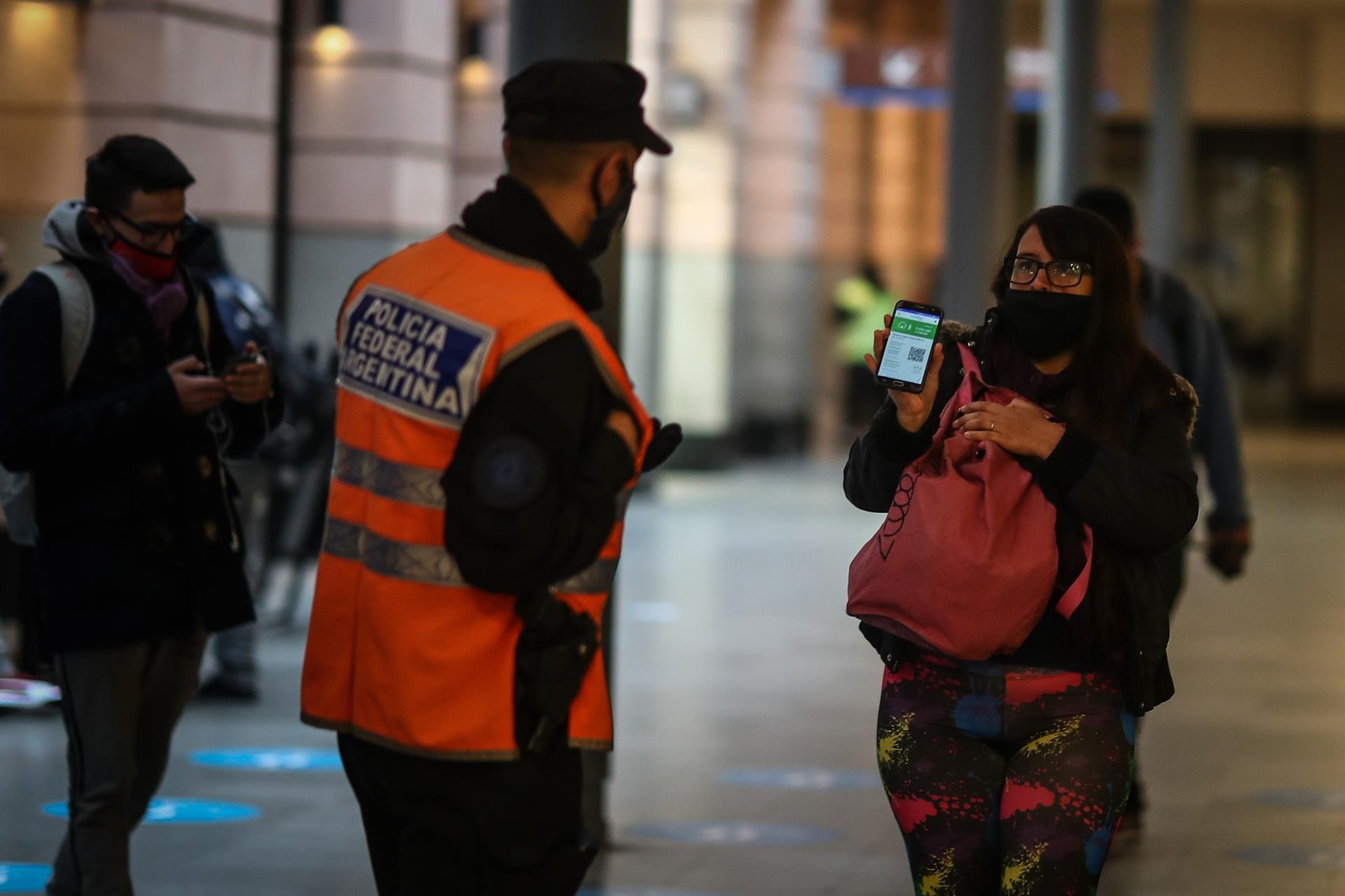 Un policía verifica que una ciudadana circule por la ciudad por estar dentro de las excepciones en el confinamiento. 