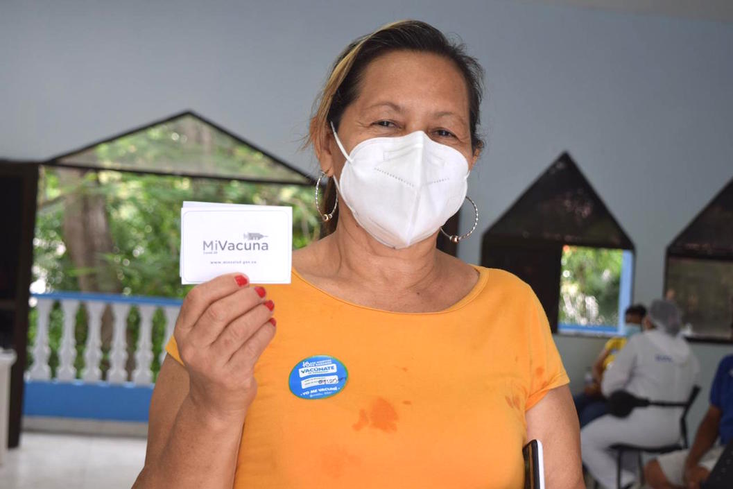 Una mujer exhibiendo el certificado de vacunación.