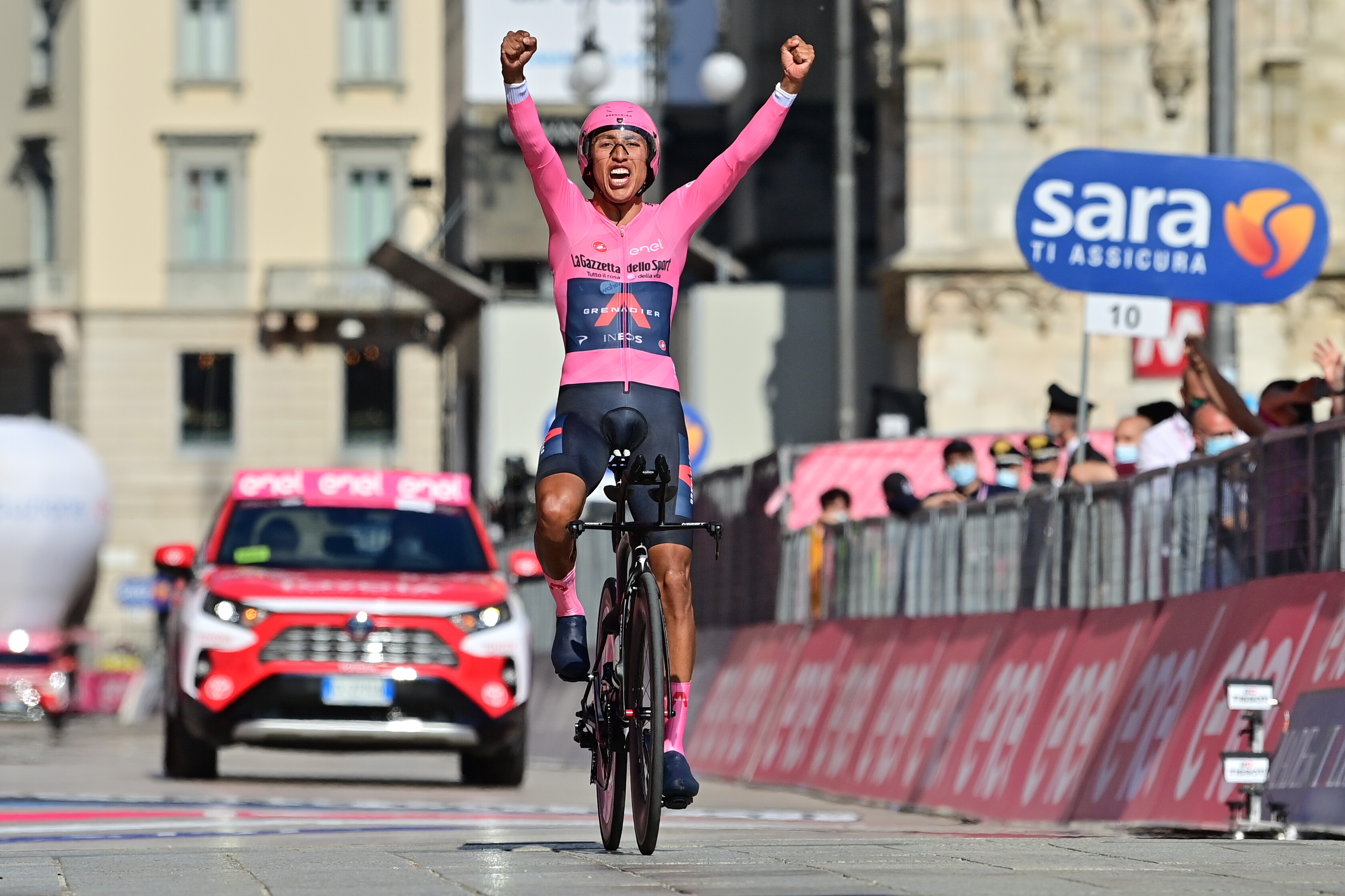 Egan Bernal al cruce por la meta, levanta los brazos. 