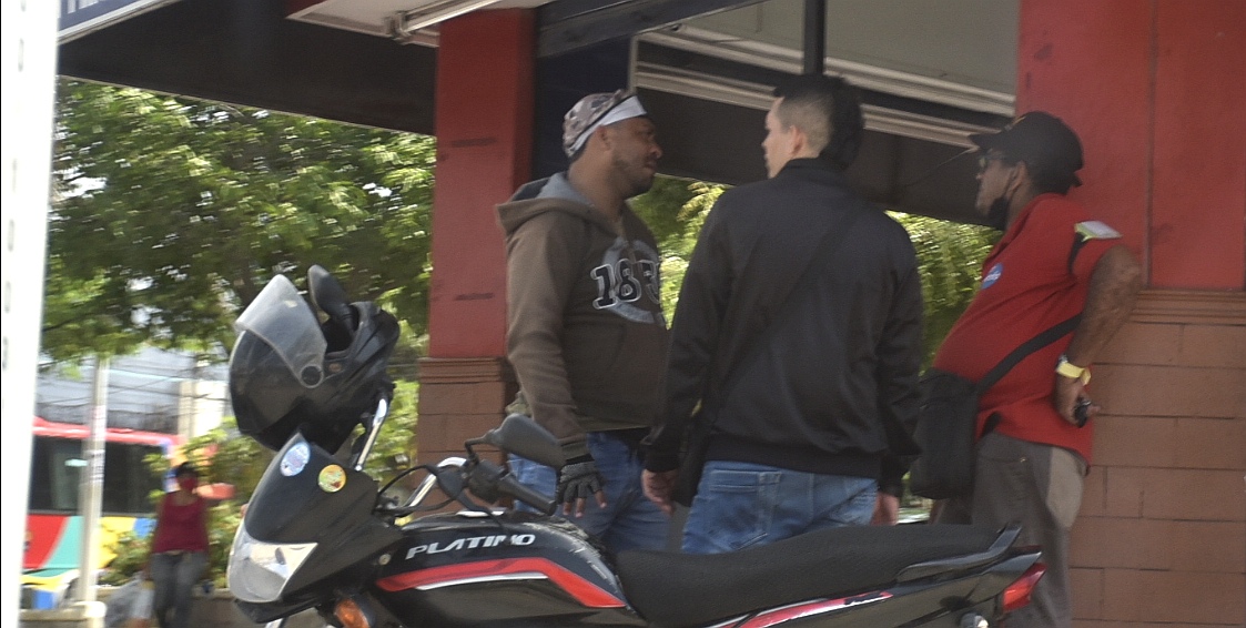 Tres personas conversan sin tapabocas y sin distanciamiento.