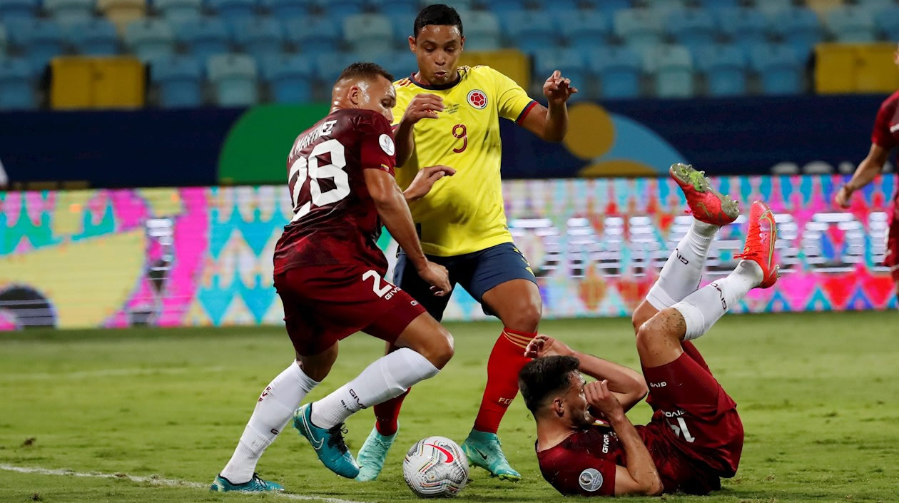 Luis Fernando Muriel intentando ingresar ante la marca de dos rivales.