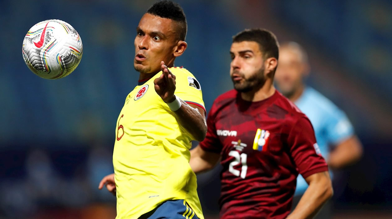 William Tesillo disputando el balón con Alexander González.