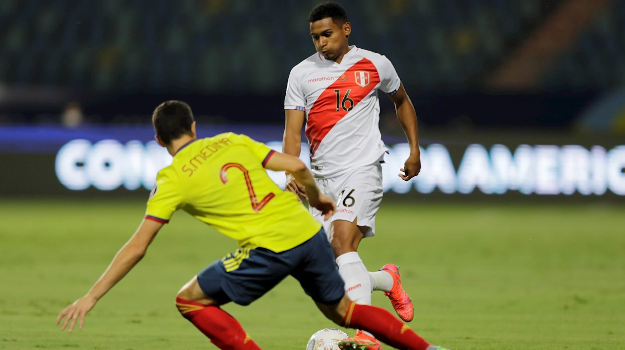 Stefan Medina de Colombia disputa un balón con Marcos López.