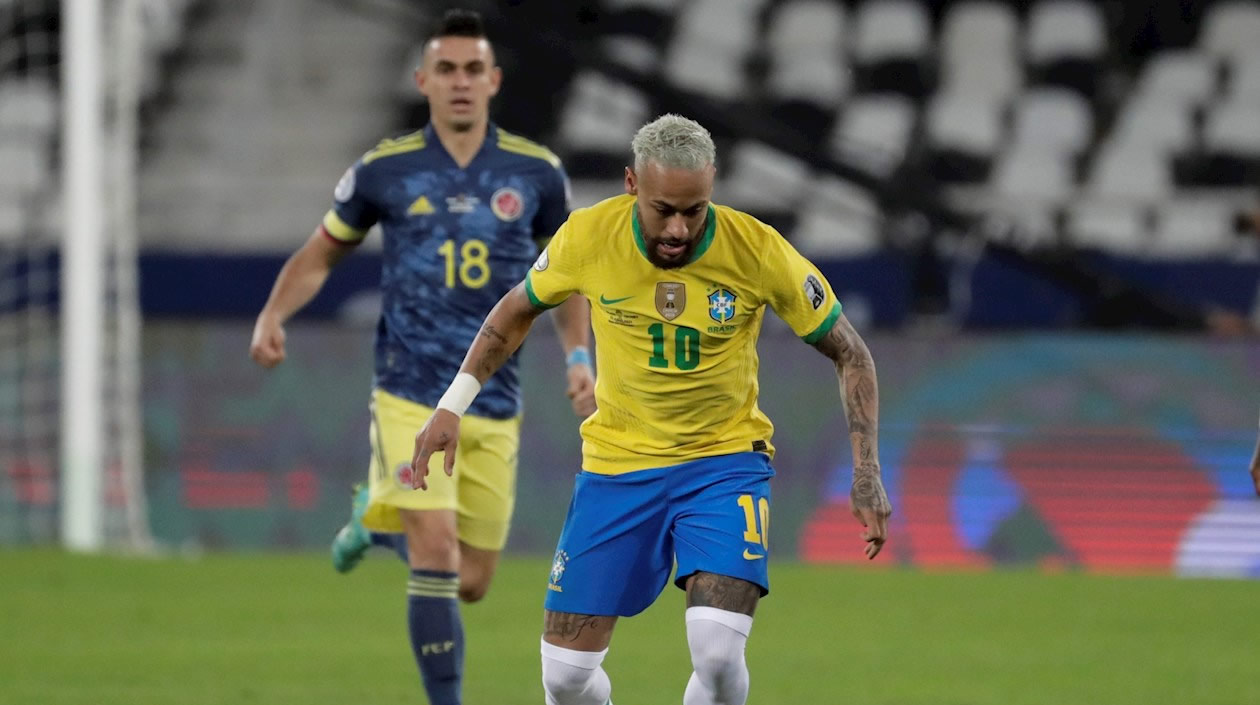Richarlison disputa el balón con Wilmar Barrios de Colombia