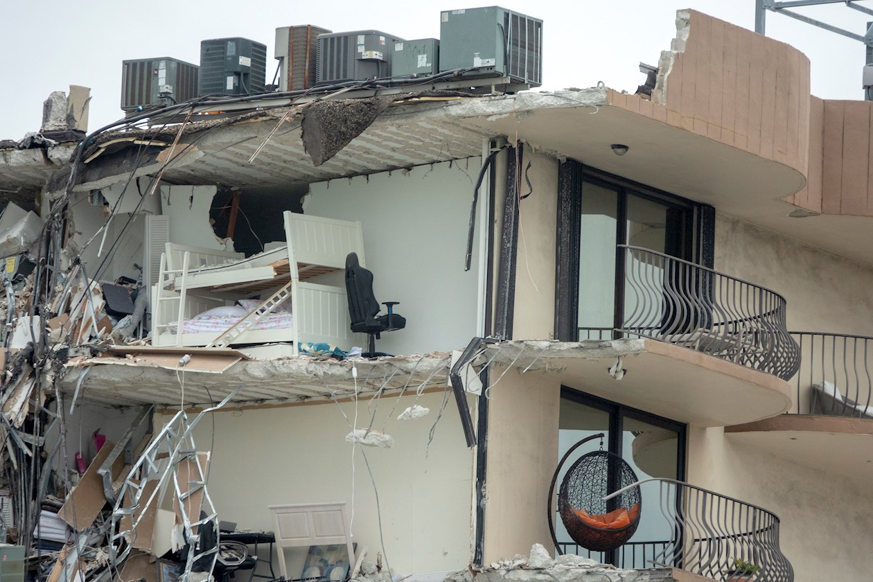 Los aparatos del aire acondicionado cuelgan de sus propios cables de electricidad sobre un amasijo de hierros y toneladas de cemento que cayeron de este edificio construido 40 años atrás.