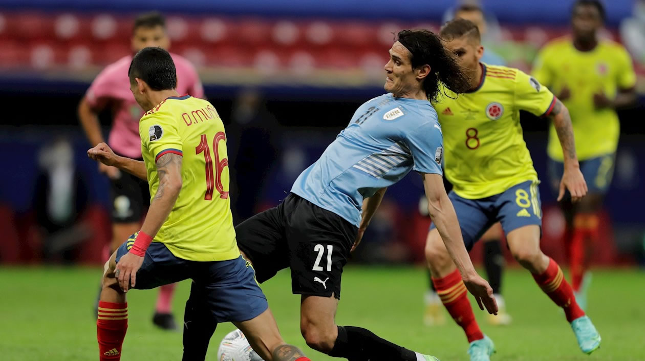 Edinson Cavani intentando eludir la narca de Daniel Muñoz.